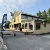 The exterior of PERKS with a blue and white OPEN flag