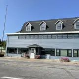 Exterior of a large building with ample parking space an a sign reading Tracy's Rustic Relics