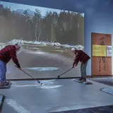 An older man and lady use the river driver log simulator