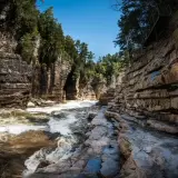 A view of the water rushing past with the towering walls of the gorge surrounding you