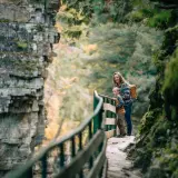 A mother and son peer over the railing into the chasm