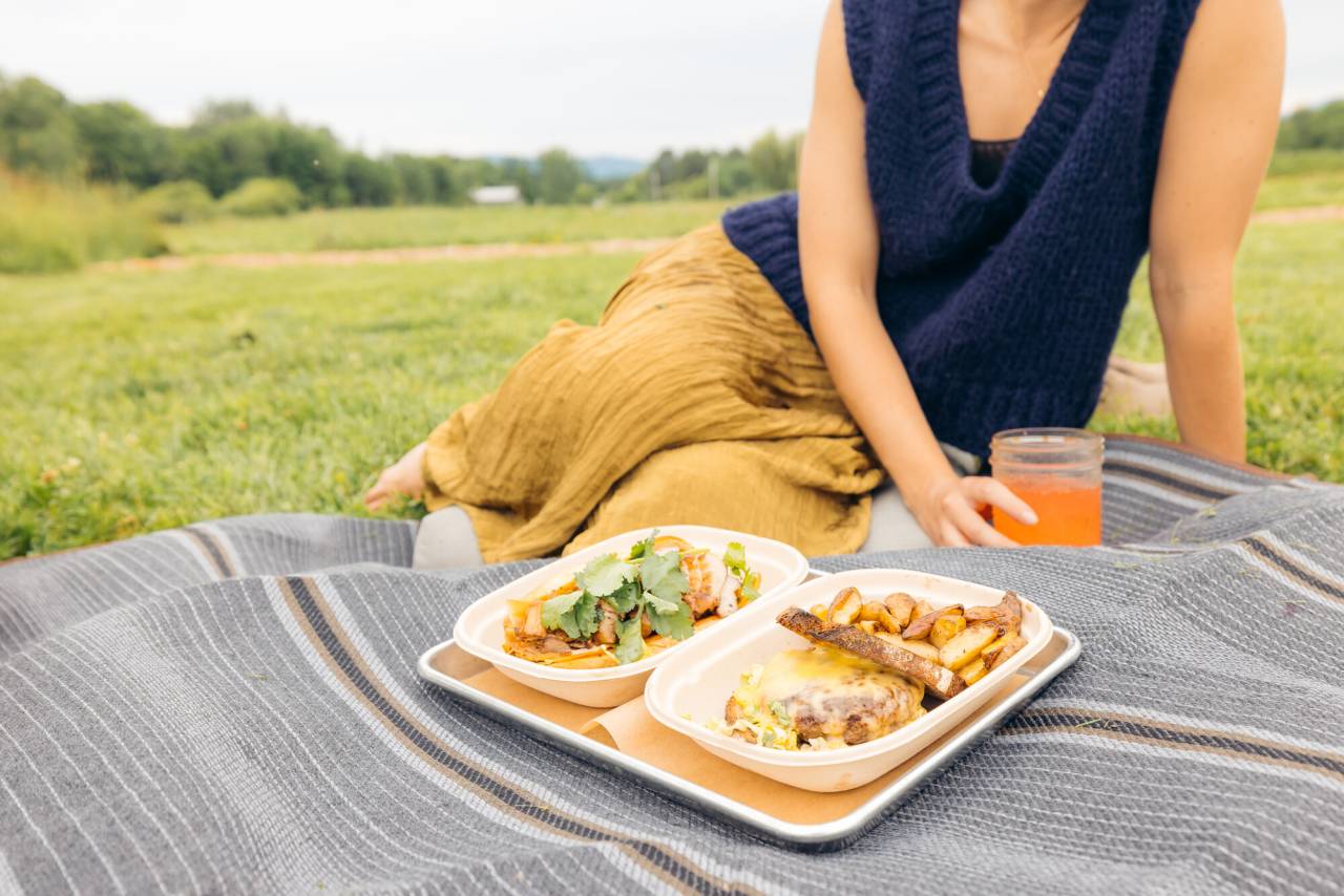 A person sitting at a picnic with food.