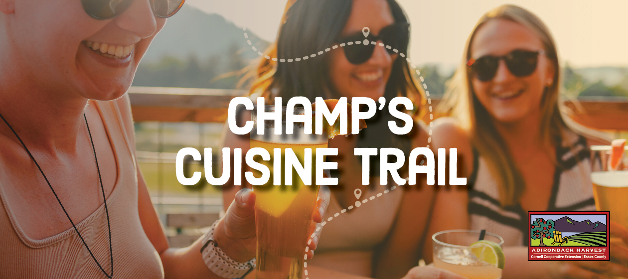 A banner in front of people holding beer saying: Champ's Cuisine Trail. 