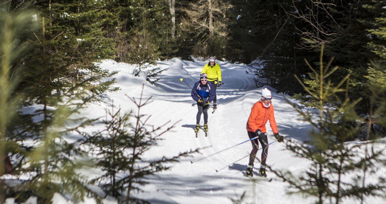 Three people skiing on a groomed trail at Lapland Lake
