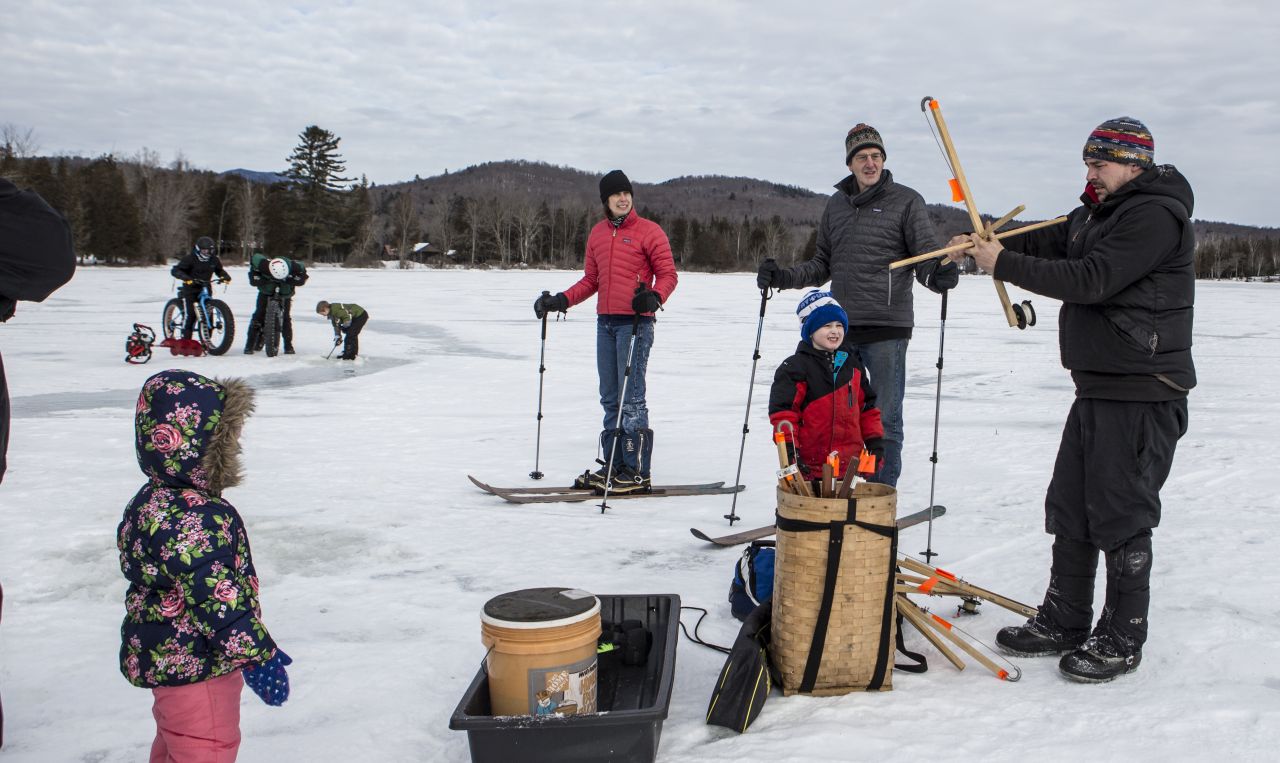 Adults and kids learning how to use a tip-up on Schroon Lake.