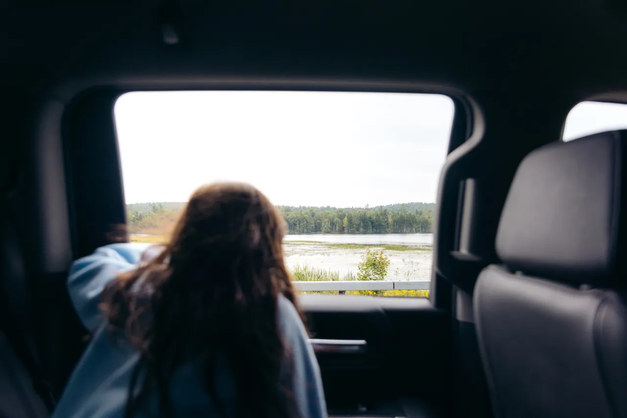 A child looking out of a car window.