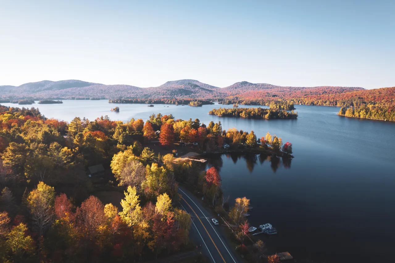 A fall road alongside a large lake.