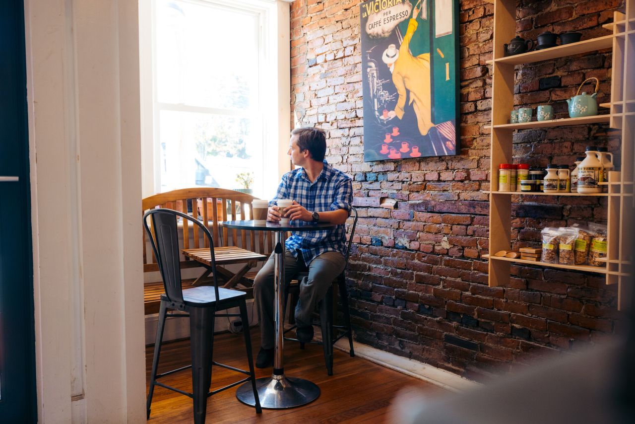 A guy drinking coffee at Jambs on Main coffee shop