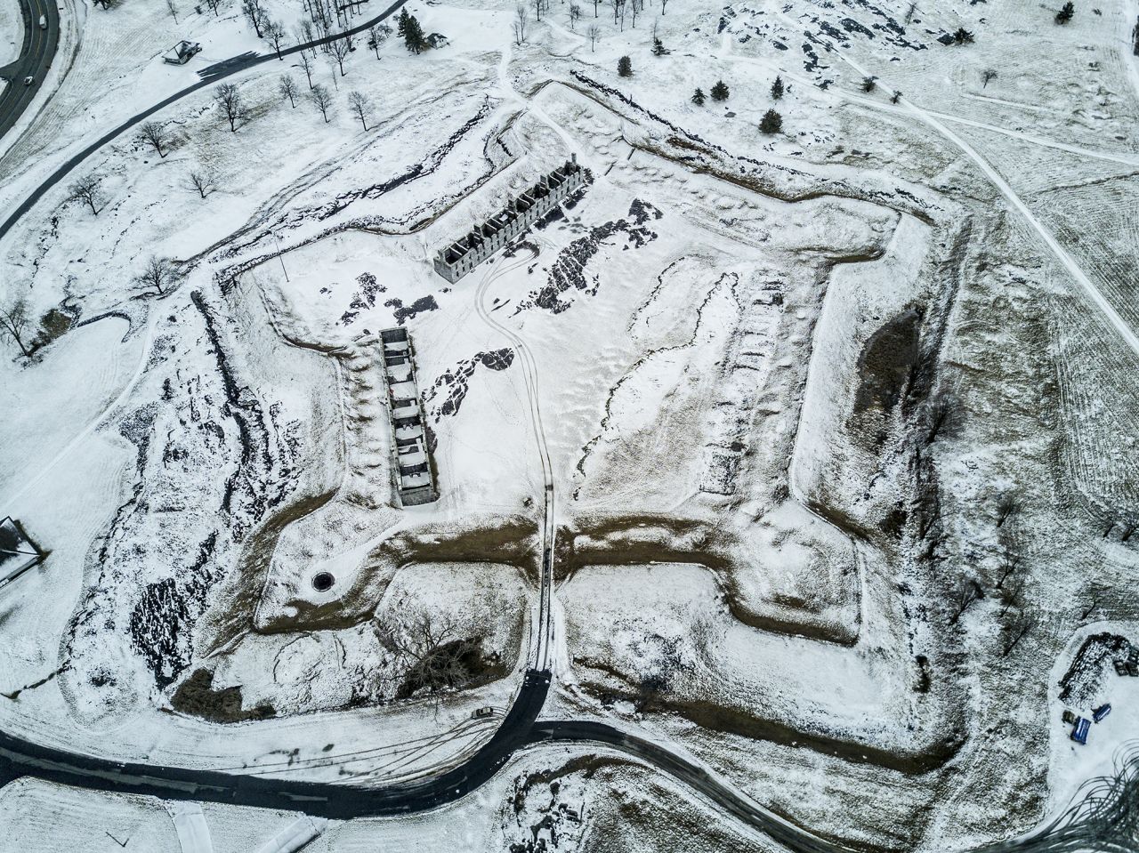 An aerial view of a star shaped Revolutionary War fort in winter.