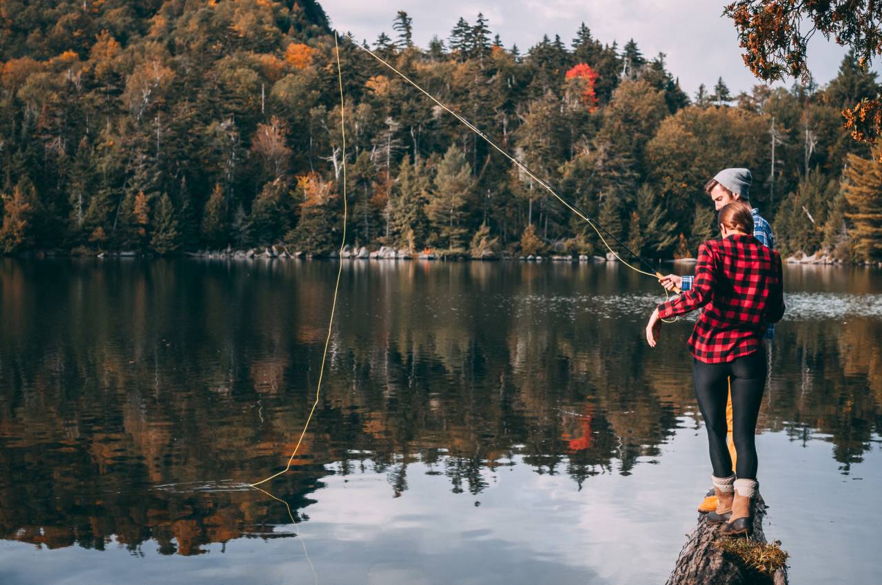 A couple fly fishing in the fall.