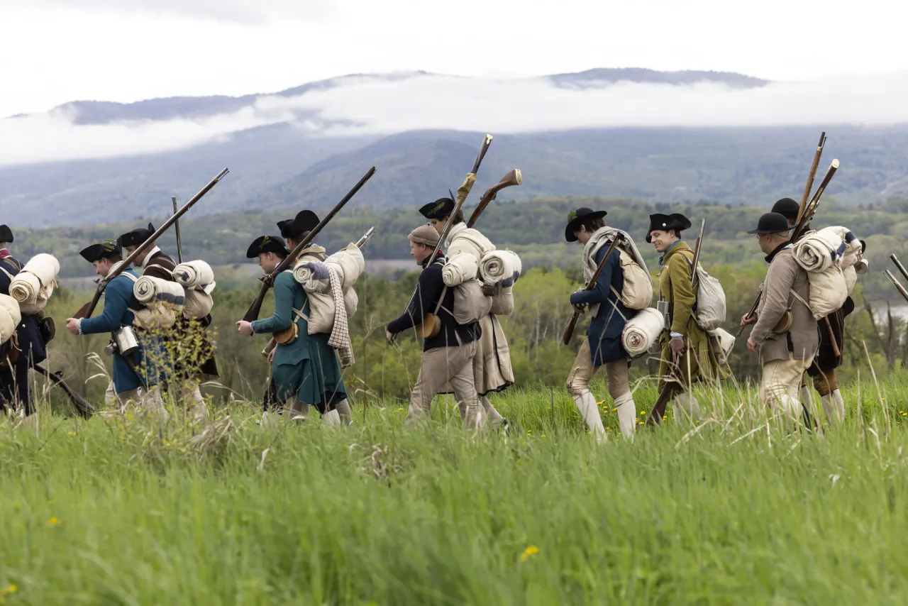 reenactors marching through the woods