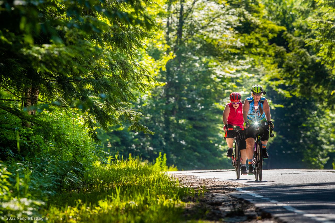 Two bikers riding along a road.