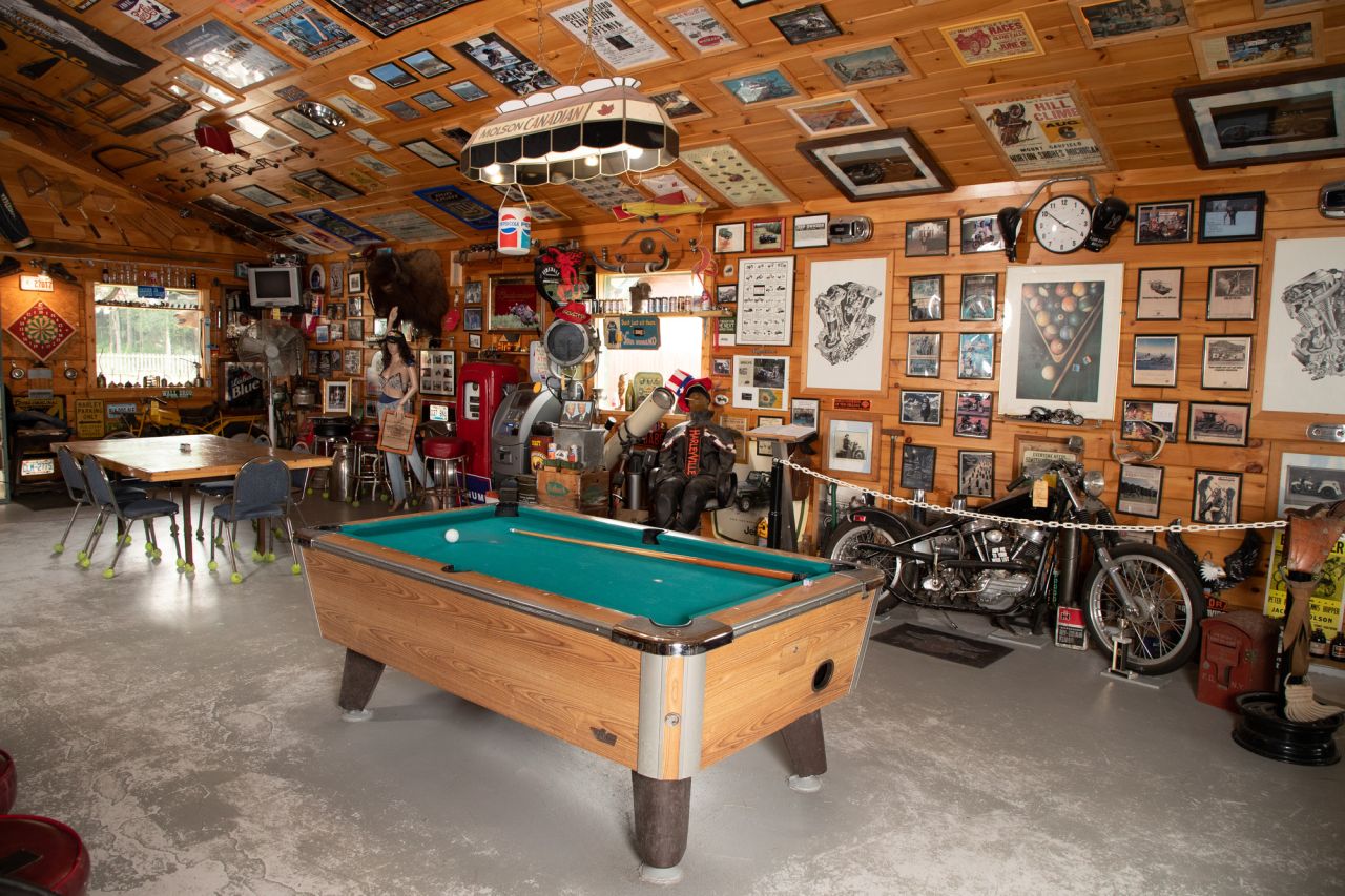 A bar with motorcycle memorabilia and a pool table. 