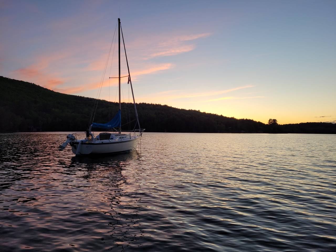 A sailboat on Lake Champlain during sunset.
