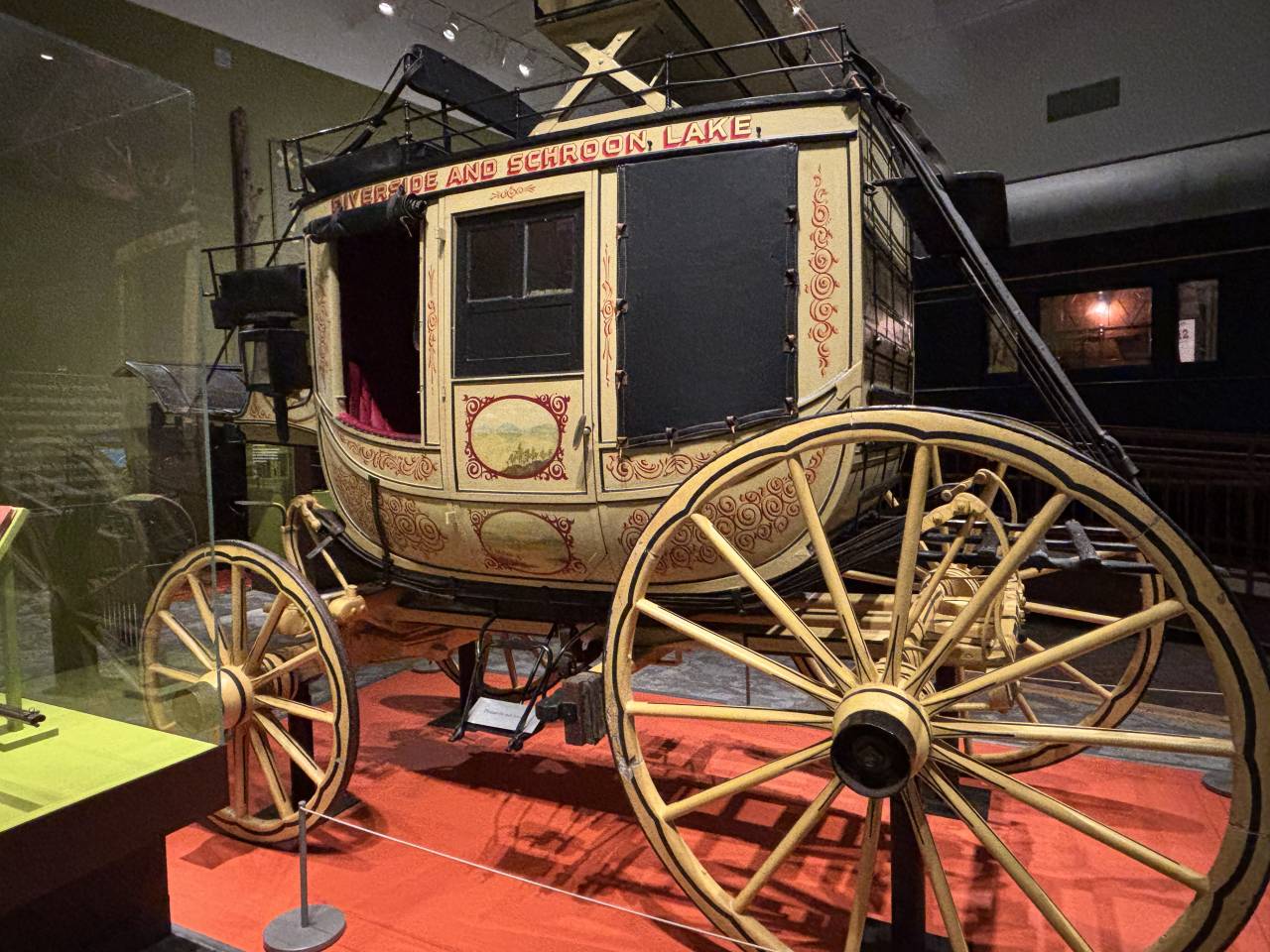 A yellow-green stagecoach inside a museum exhibit.