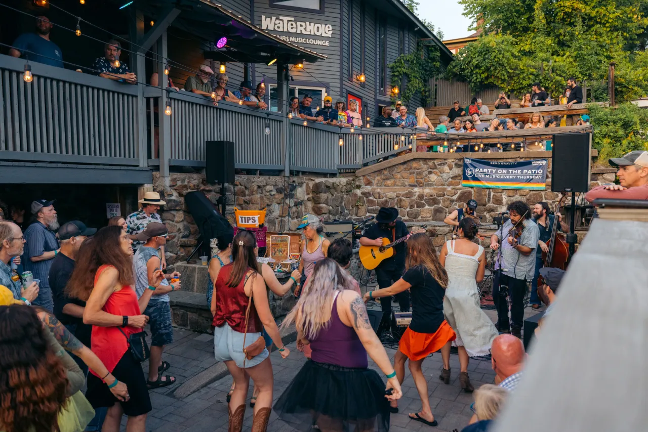 People dance and party at an outdoor venue of a restaurant.