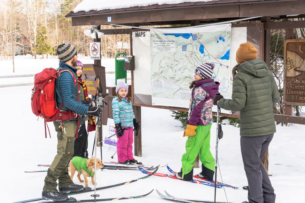 A family by a trail network map
