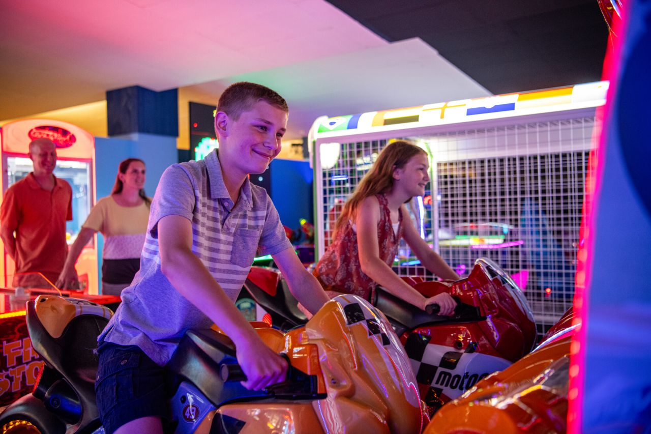 Two kids on a motorcycle simulator