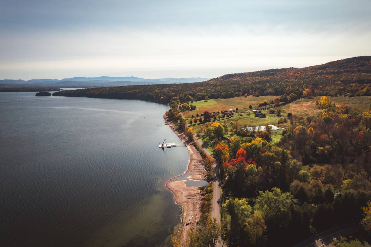 A fall countryside hugging a lake. 