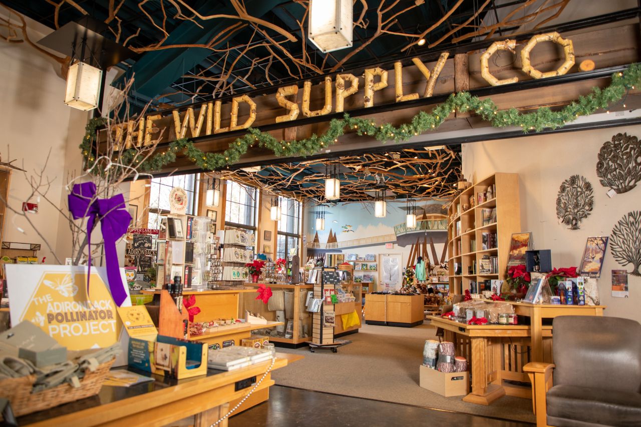 The interior of a store. A large sign made of tree branches reads "Wild Supply Co."
