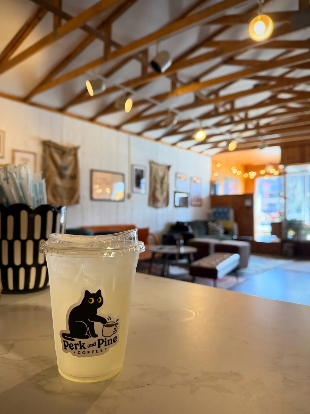 Perk and Pine cup with a black cat logo sticker