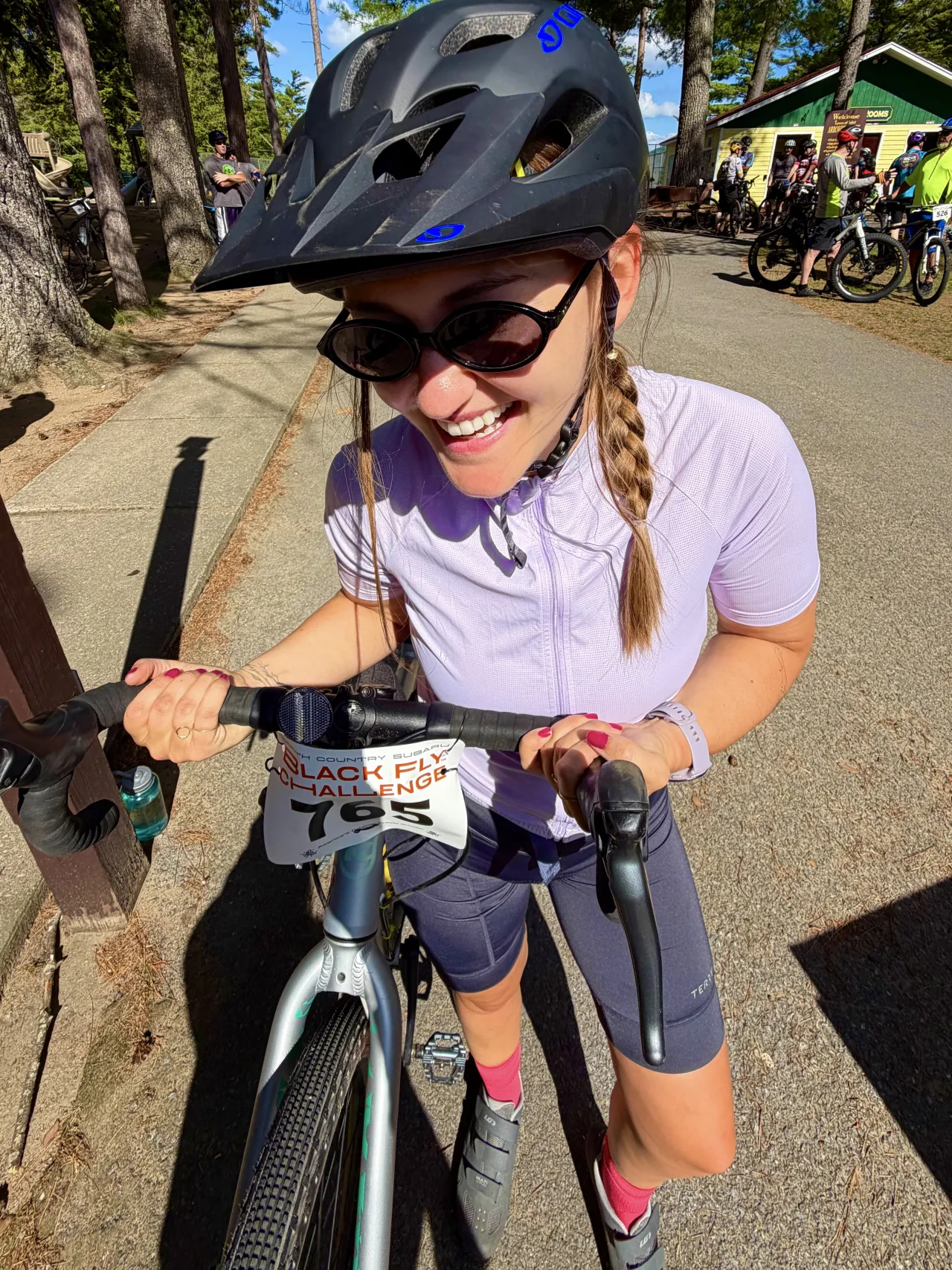 A woman posing with her bike at a gravel race.