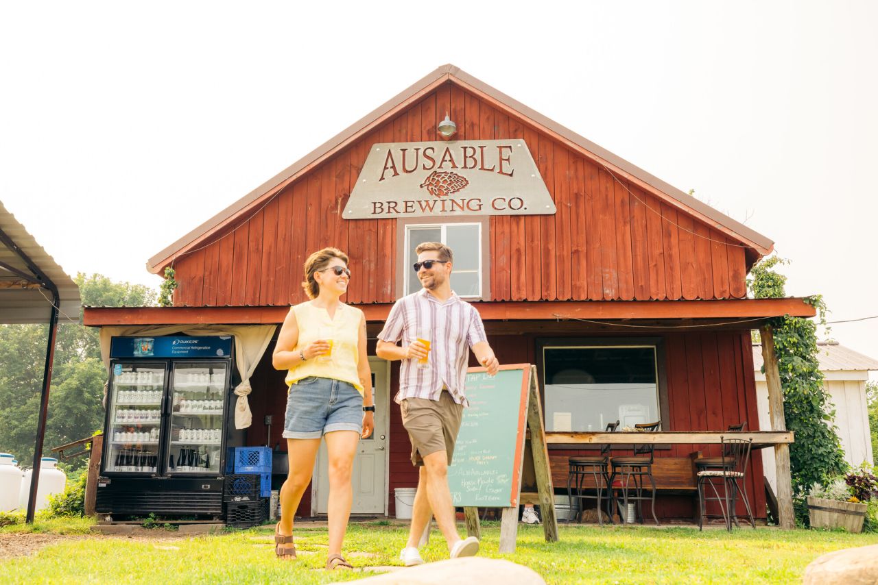 two people in front of ausable brewing