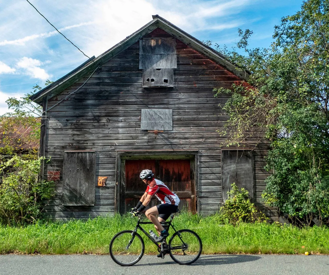 Gravel biking by a barn.