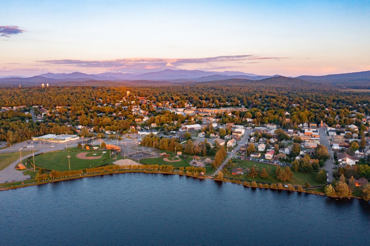 An aerial view of a small town on a lake in the mountains. 