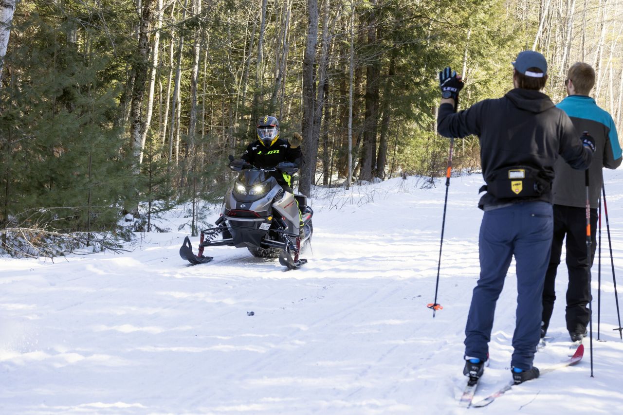 Snowmobilers and cross-country skiers sharing the trail.