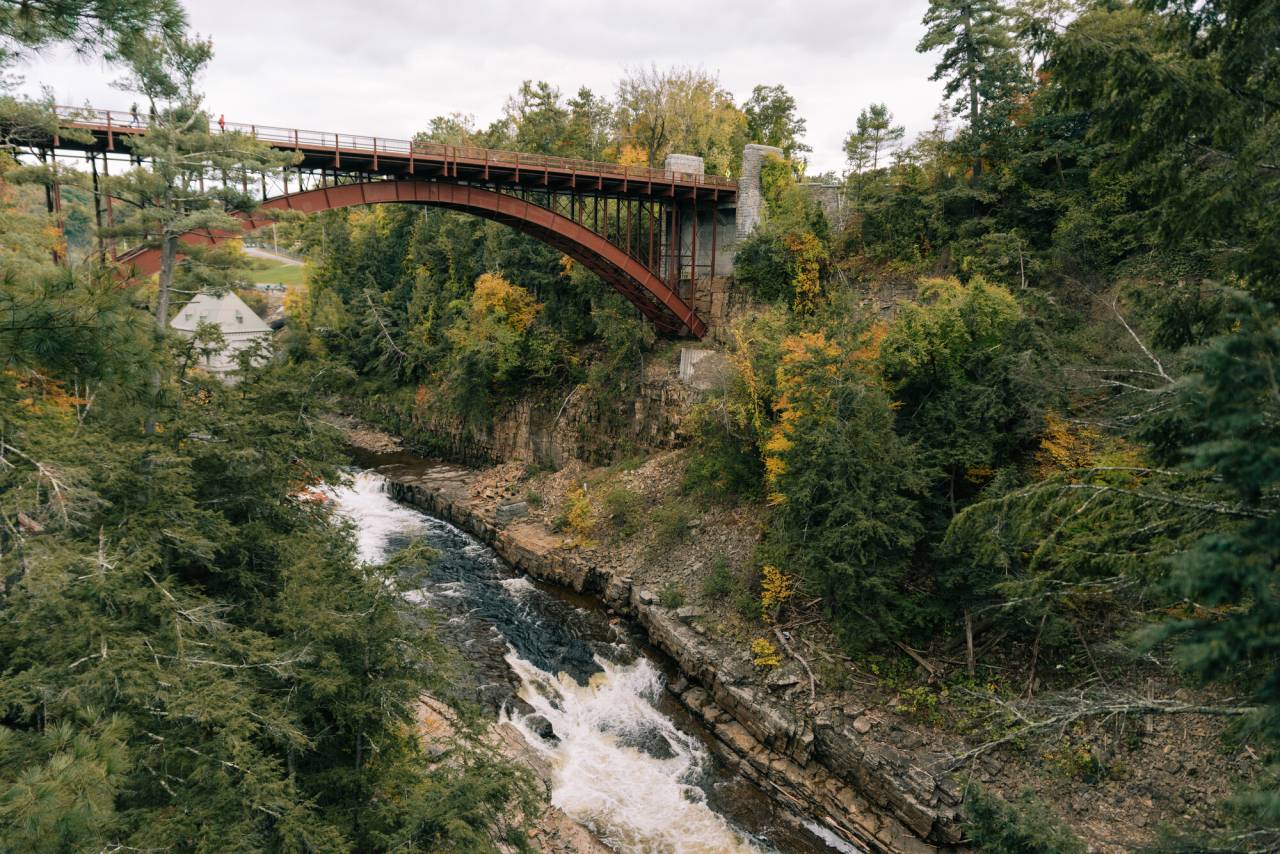 A bridge with a rushing river underneath it. 