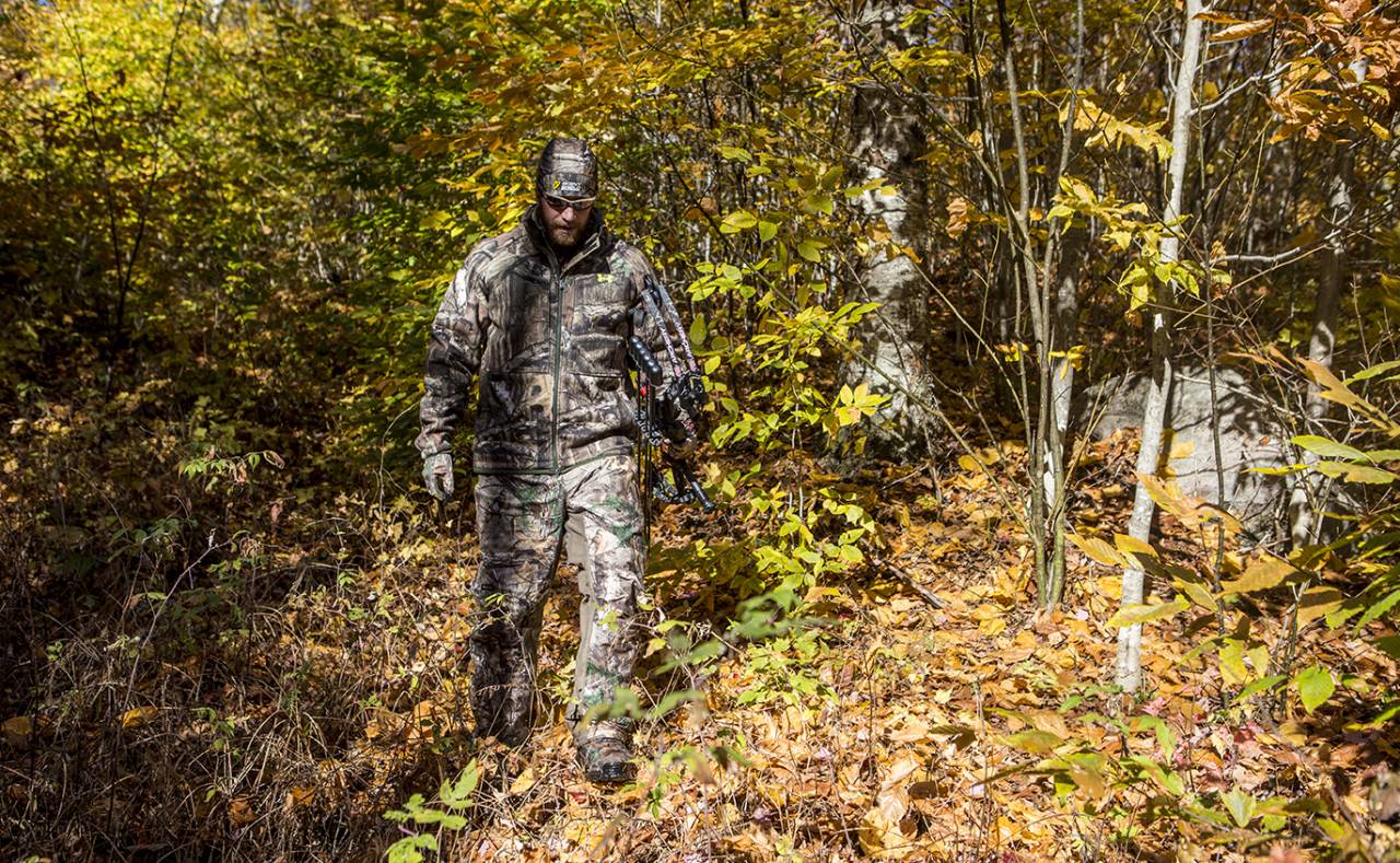 A hunter walking through a fall forest.