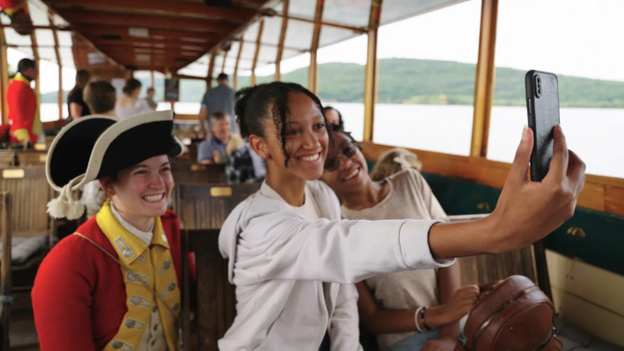 A woman taking a selfie with war reenactors at Fort Ticonderoga.
