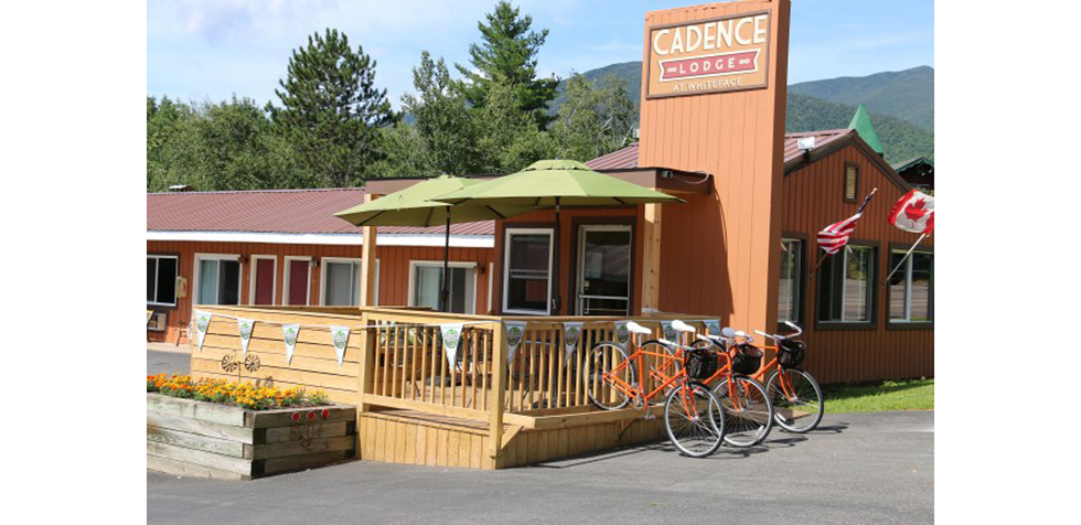 A retro lodge with three bikes parked out front. 
