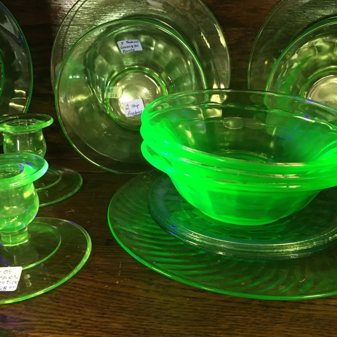Close-up of a display of fluorescent green uranium glass antiques.