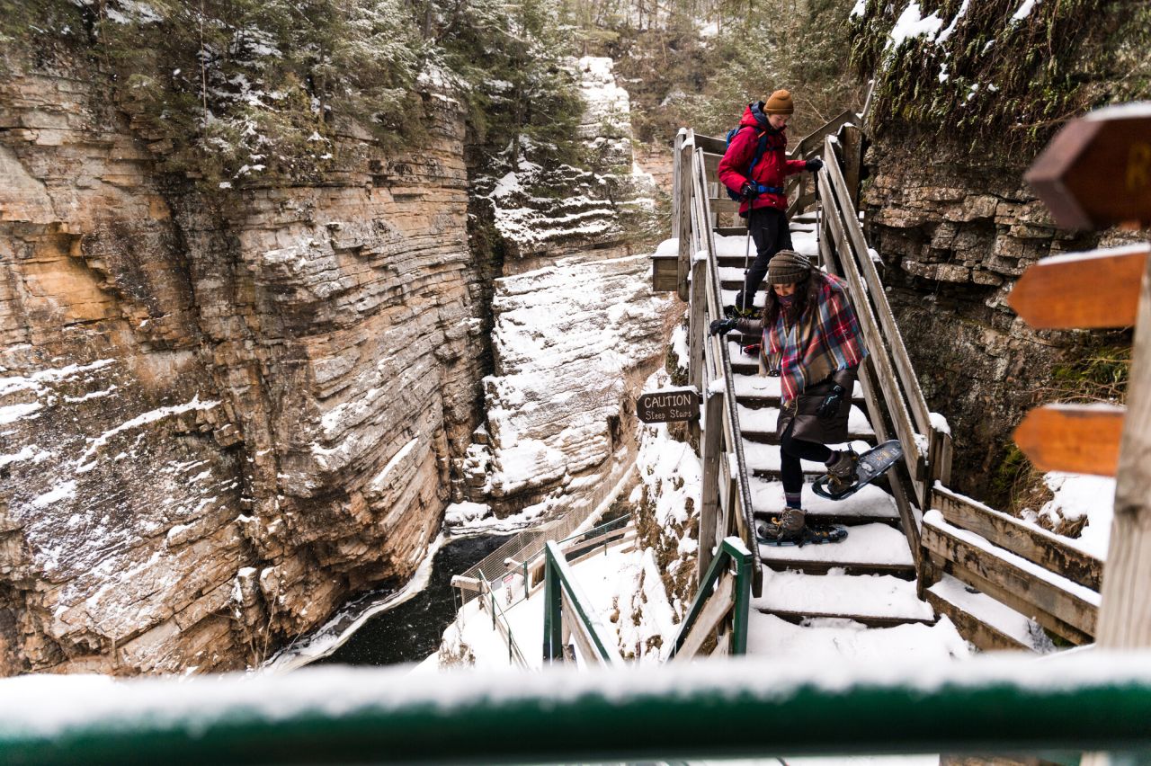 Two people exploring Ausable Chasm on snowshoes.
