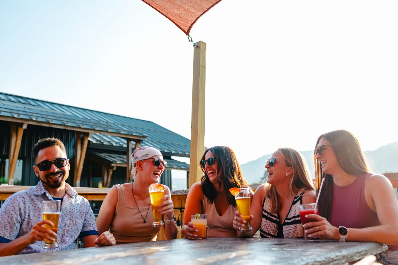 A group of friends share drinks at an outdoor brewery.