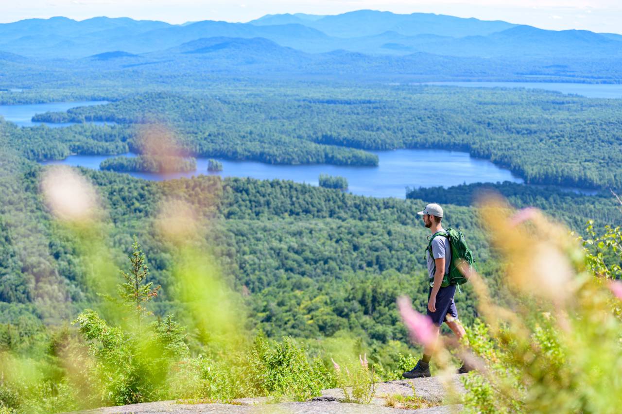 A hiker at the summit of St. Regis Mountain.