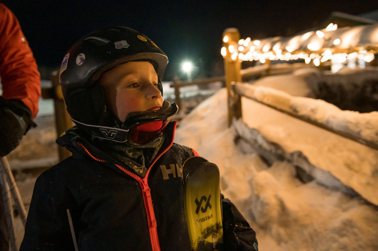 A young boy looks at lights at a ski mountain. 