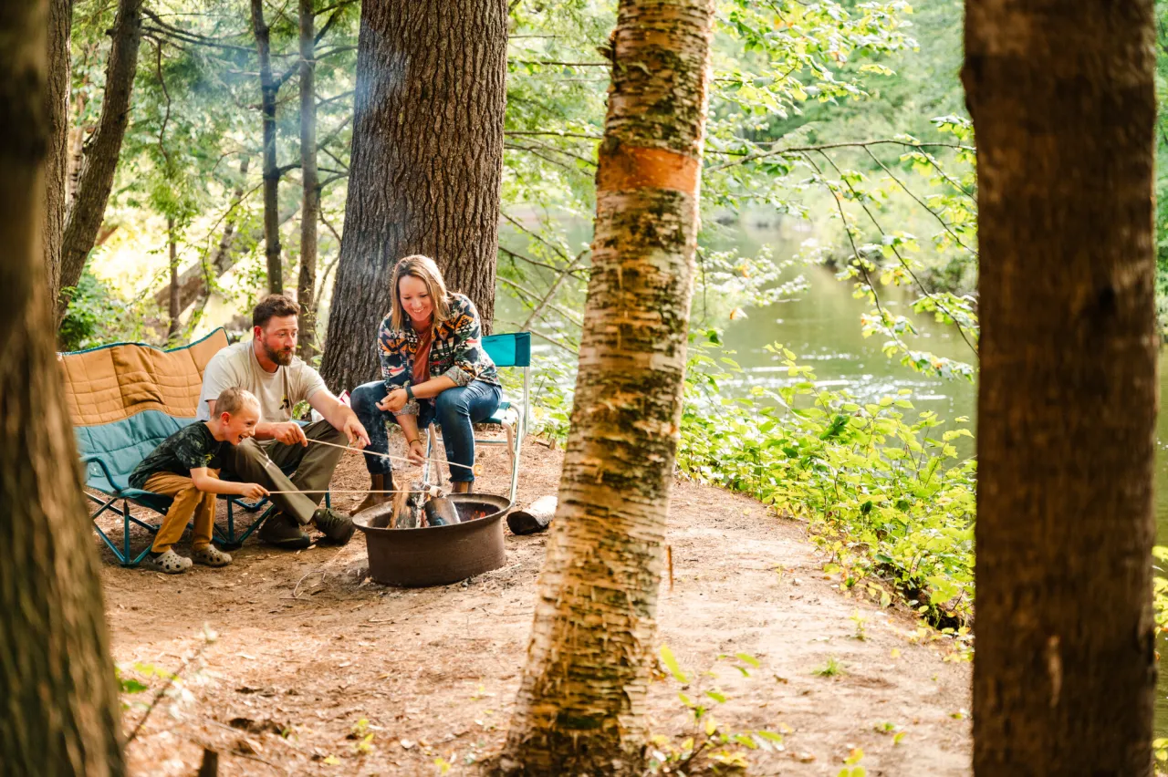 A family roasts marshmallows at a campground.