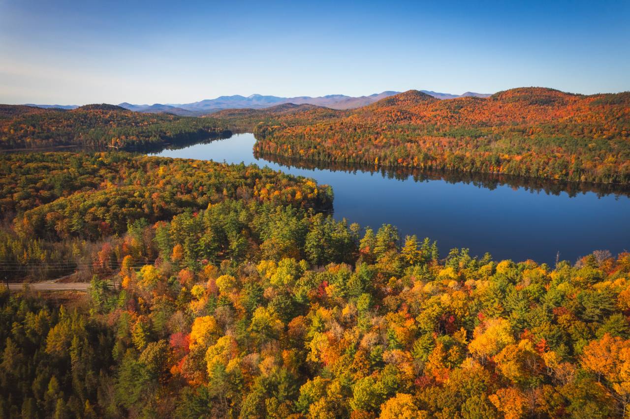A fall landscape with a lake running through the middle. 