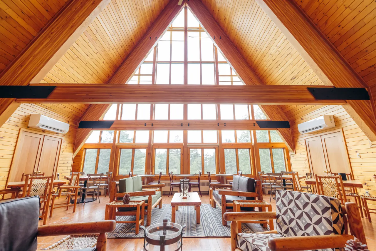 The rustic interior of a large, a-frame Adirondack lodge.