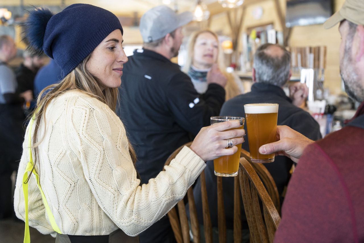 People clinking drinks at Raquette River Brewery