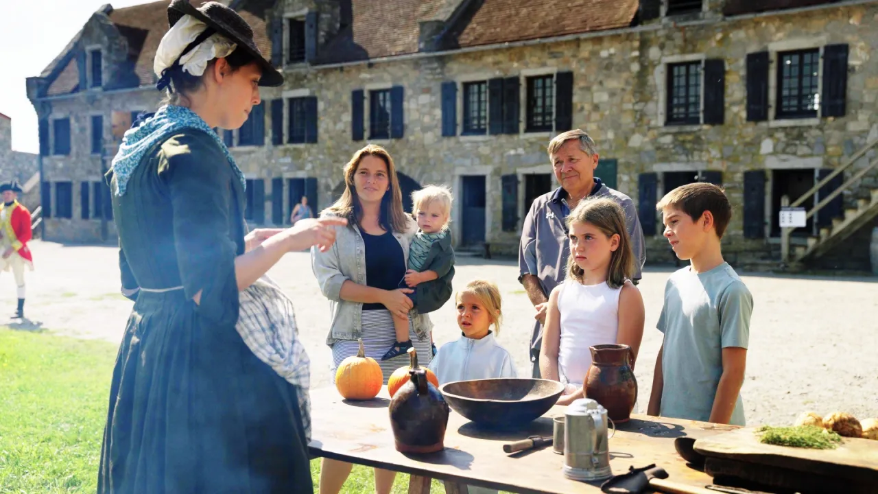 kids gathered around a woman at fort ticonderoga cooking