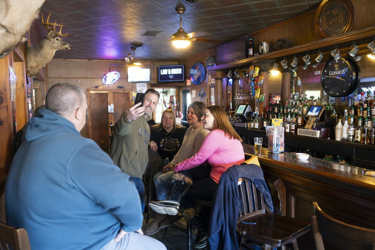 A group of people take a picture at a rustic bar.