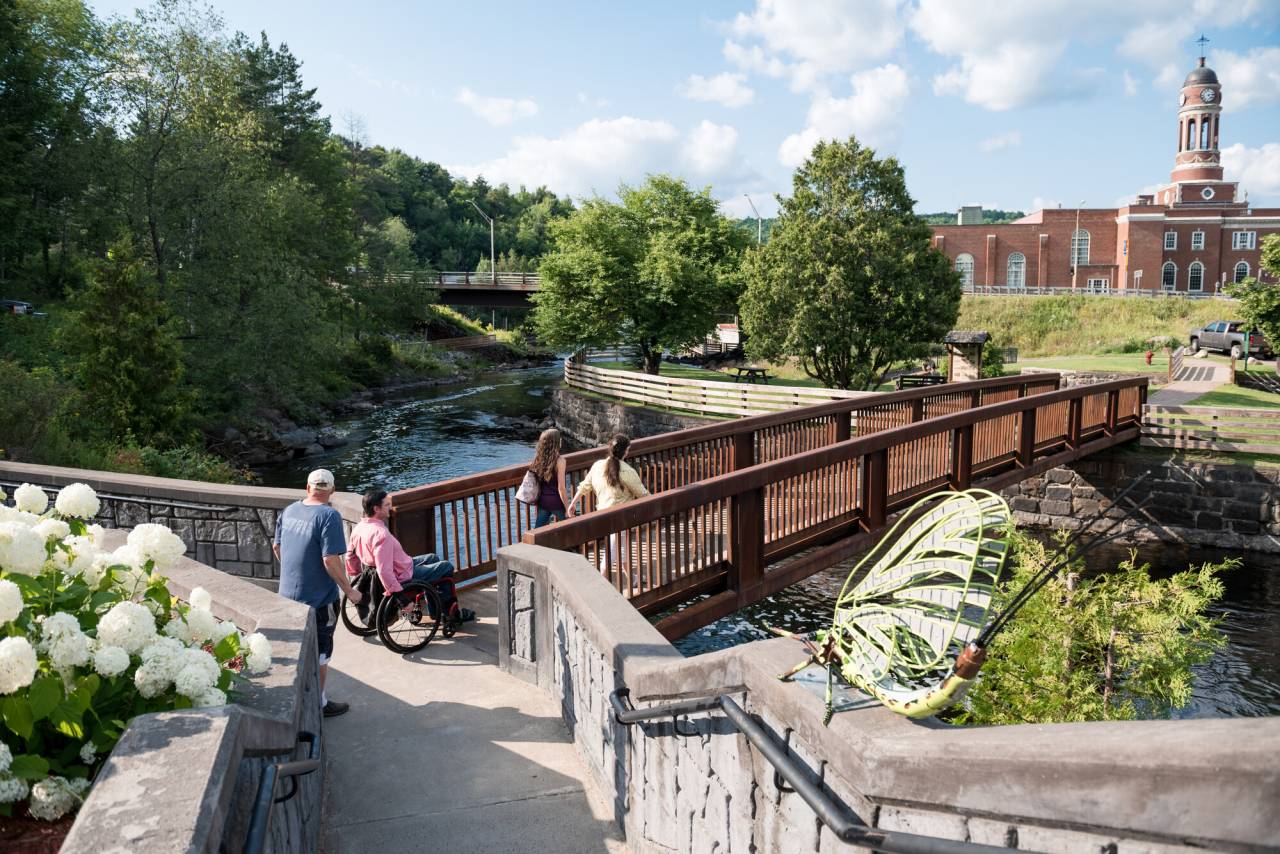 A group of people crossing a bridge in Saranac Lake.