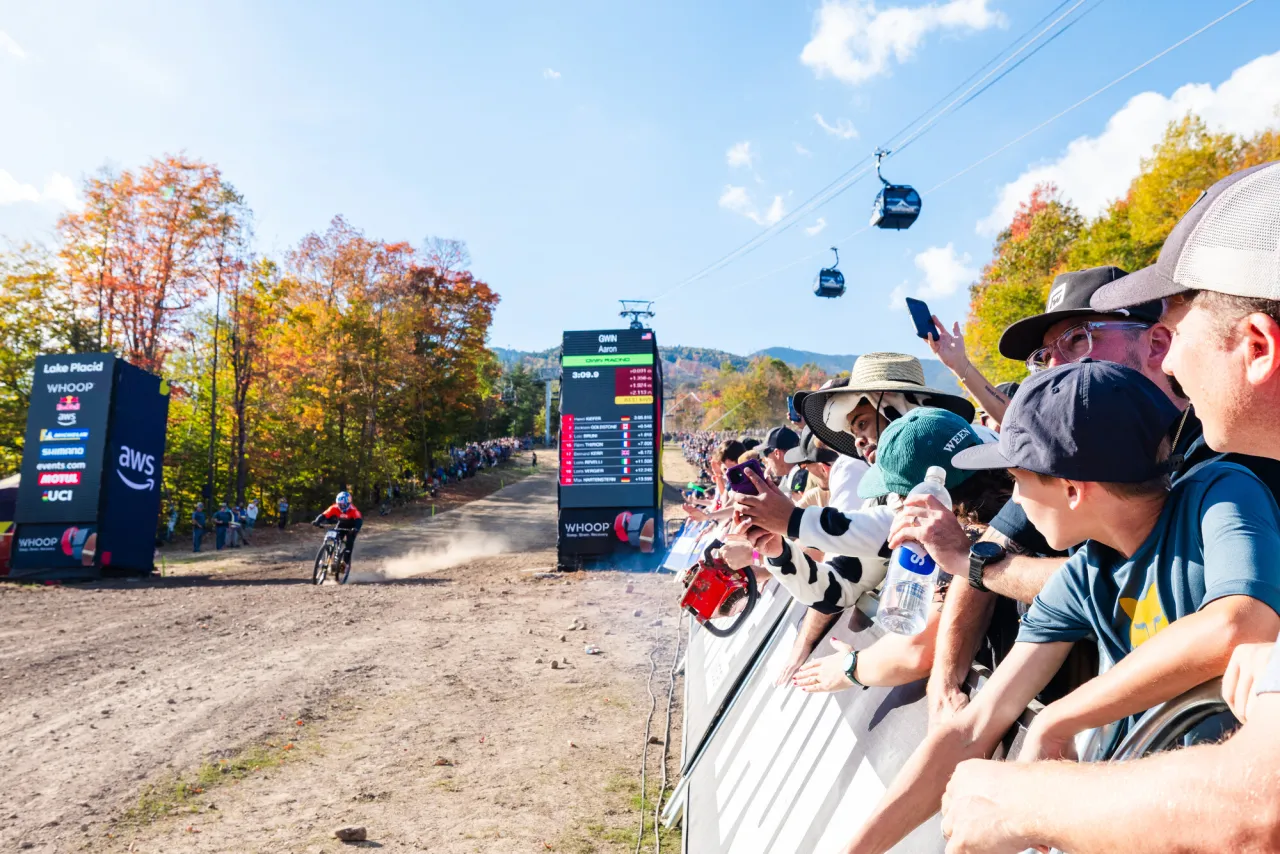 Spectators look on in finish line corral as mountain bike competitor finishes race at UCI MTB World Cup at Whiteface Mountain