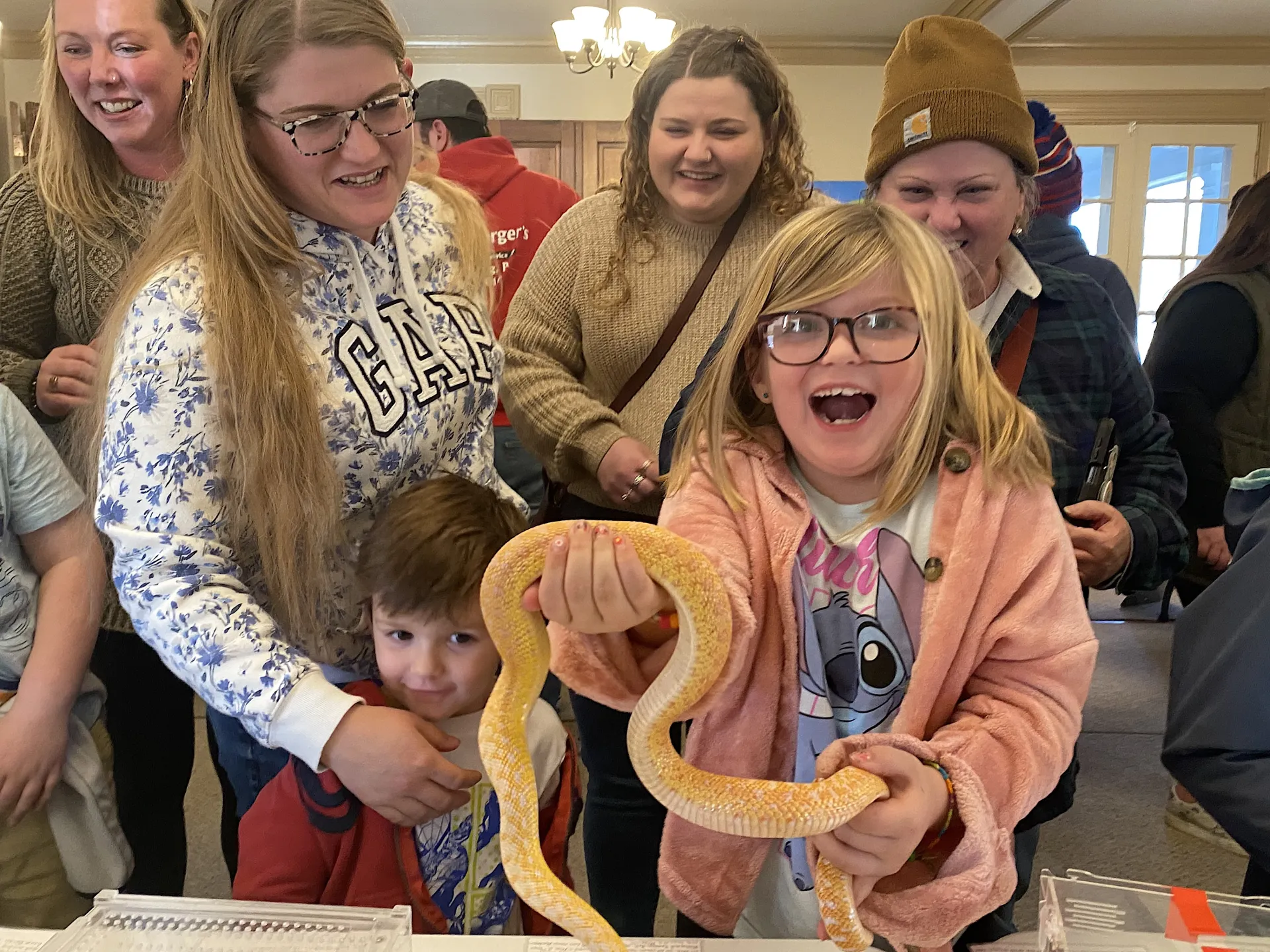 group at event holding a snake