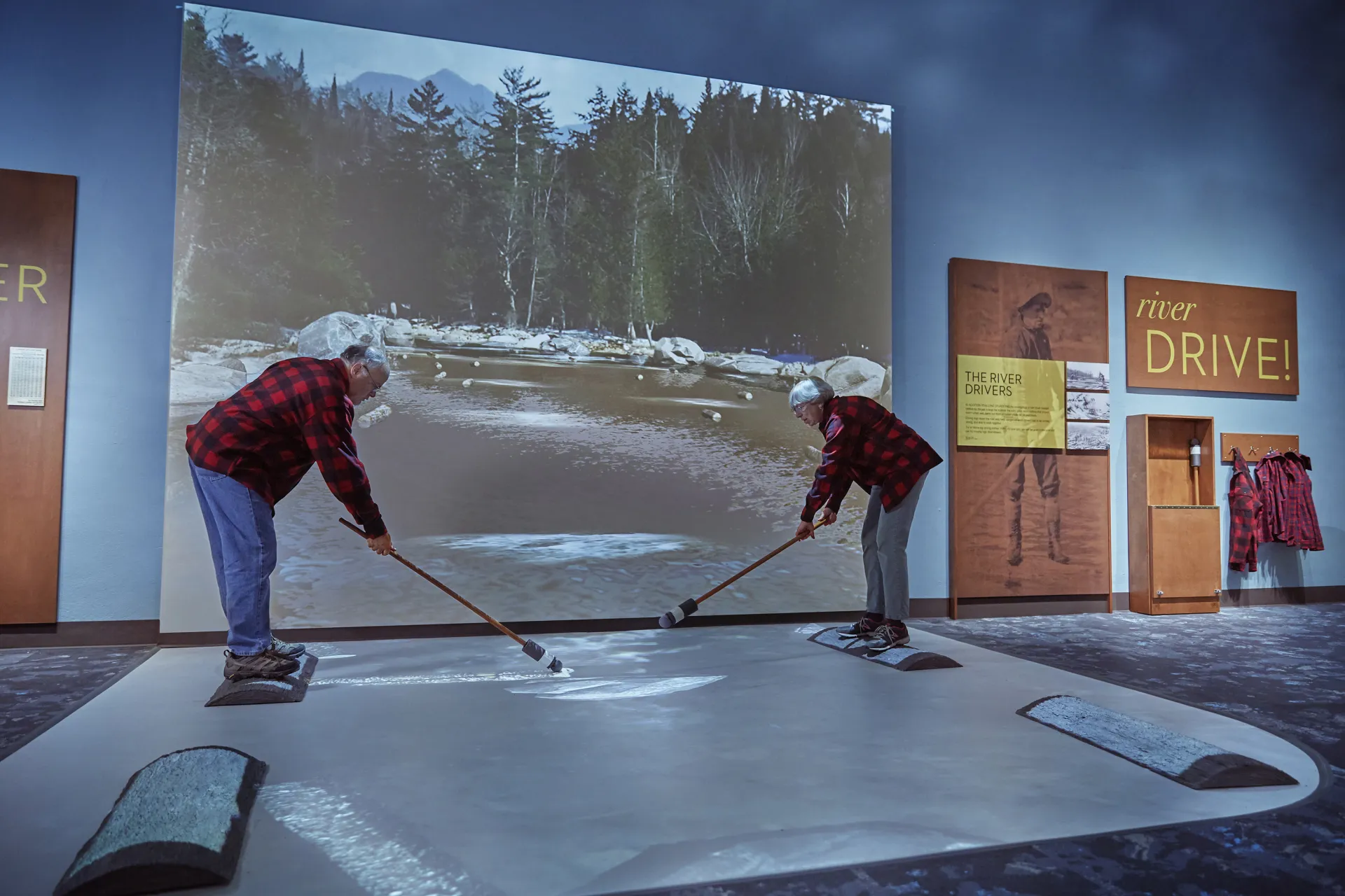 An older man and lady use the river driver log simulator