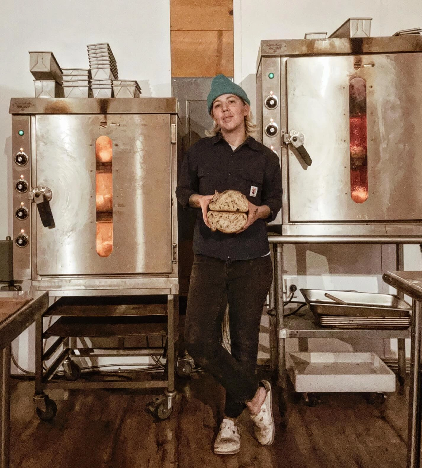 owner/baker in front of ovens